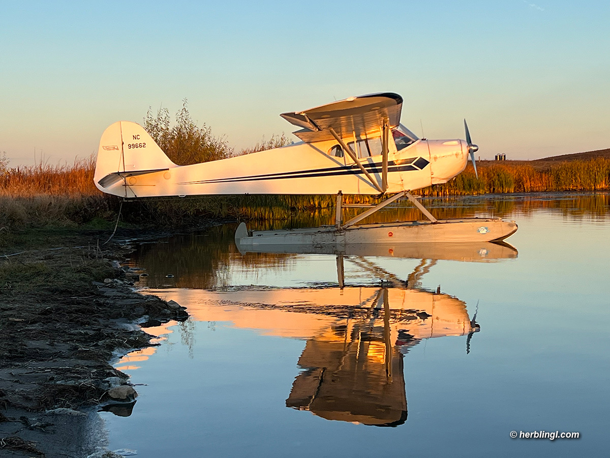 photograph of a Taylorcraft BC-12D on Edo 1320 floats at a private lake 15 miles east of Horsehead Lake, North Dakota, AHLC4716, herblingl.com